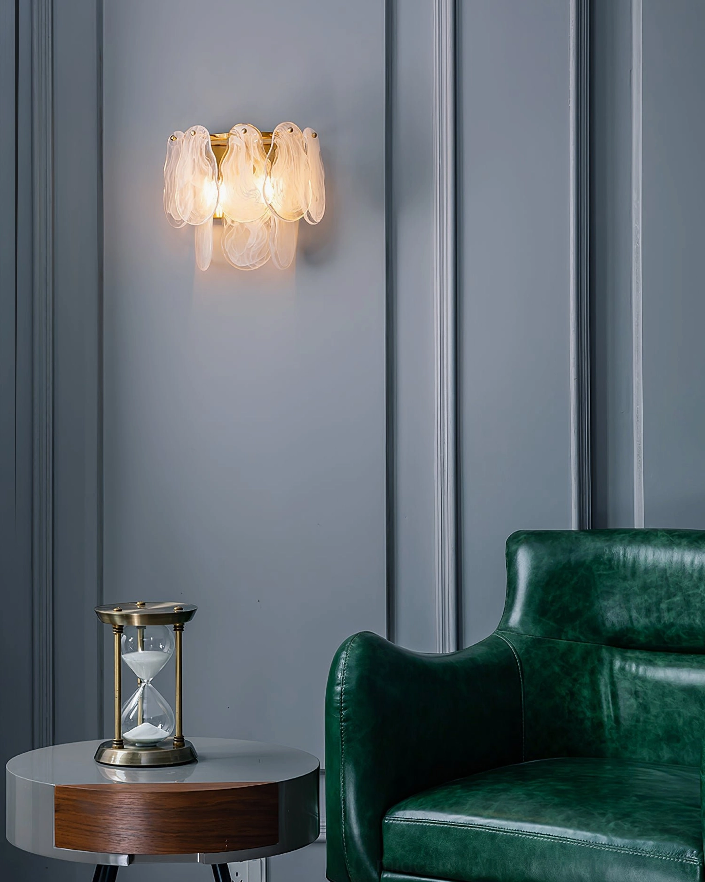 Cloud glass wall sconce in luxury living room with green leather armchair, overhead angle showing ambient warm lighting and interior styling