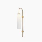 Frosted white cylindrical glass wall sconce with curved brass arm and dual gold accents on white background