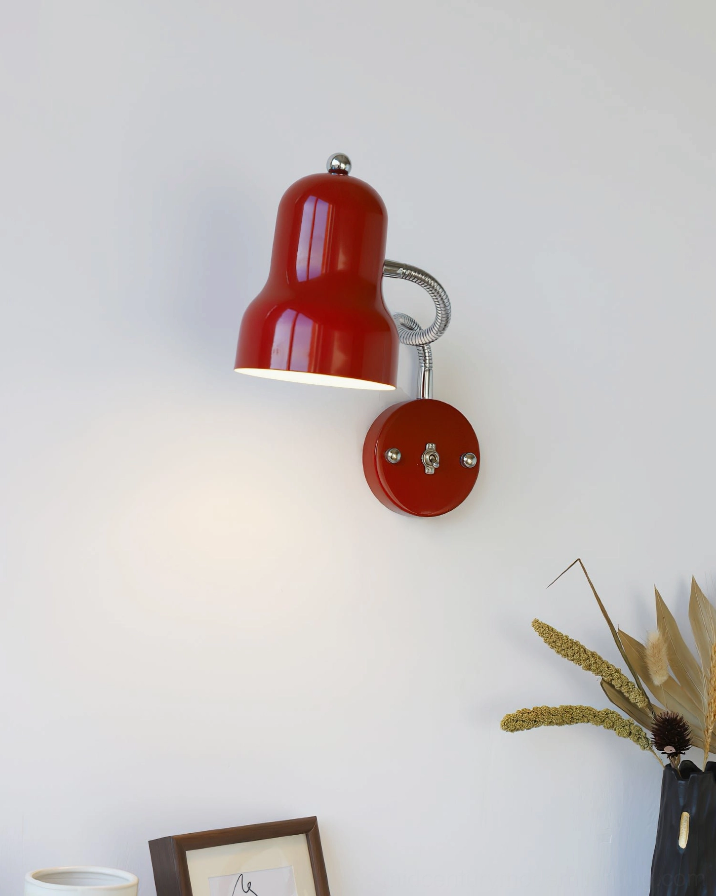 Mid-century industrial style red wall lamp with polished chrome accents and articulated arm design
