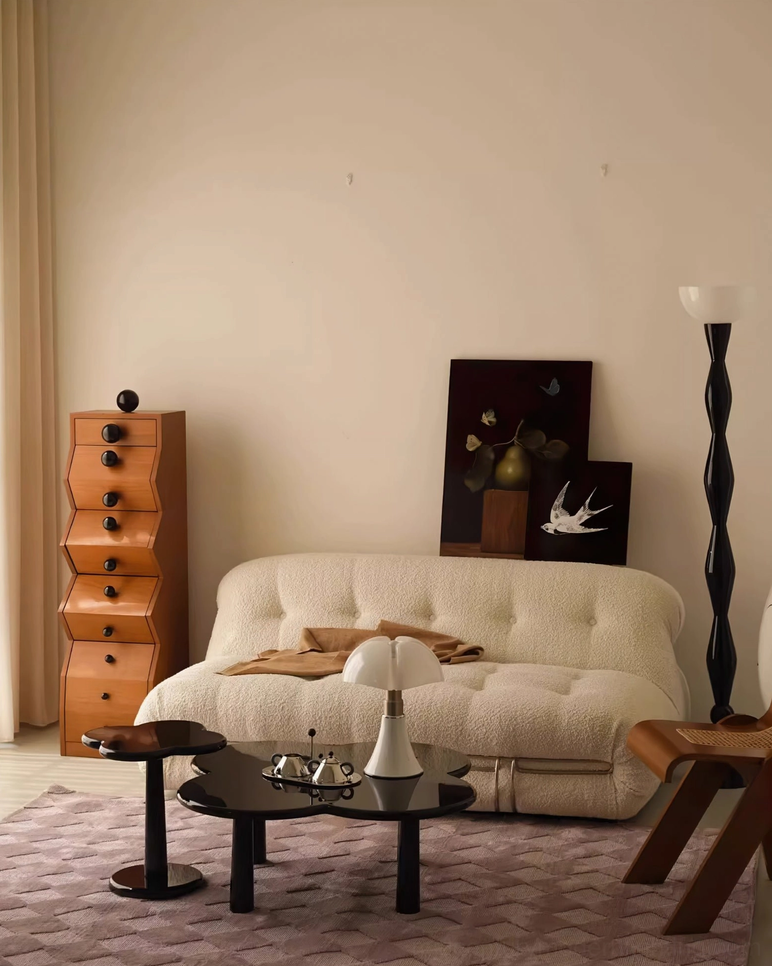 Mid-century modern black floor lamp in warm living room with tufted sofa and framed artwork gallery wall