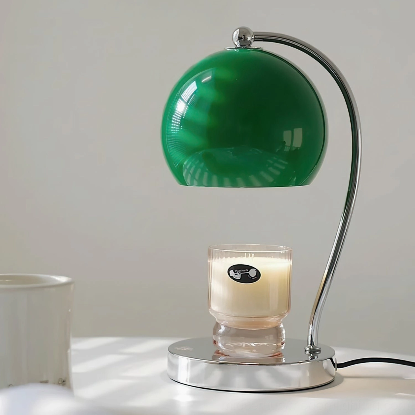 Green spherical glass shade lamp with polished silver metal base three-quarter view minimalist design