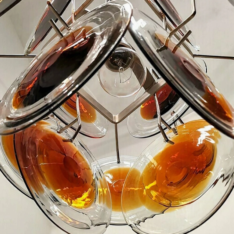 Additional angle of mid-century modern amber glass disc chandelier with nickel metal framework