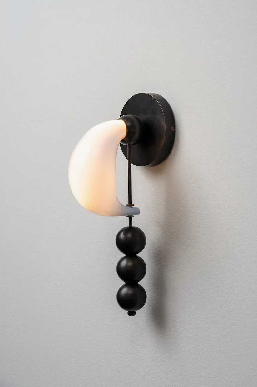 Mid-century modern bent glass wall sconce with integrated LED technology, minimalist sculptural design in contemporary interior