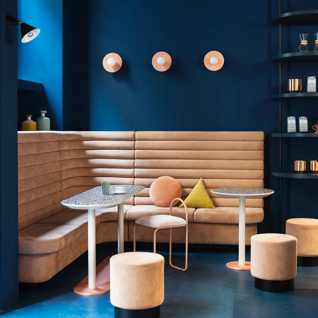 Paired brass disc sphere wall lamps in trendy café dining booth setting