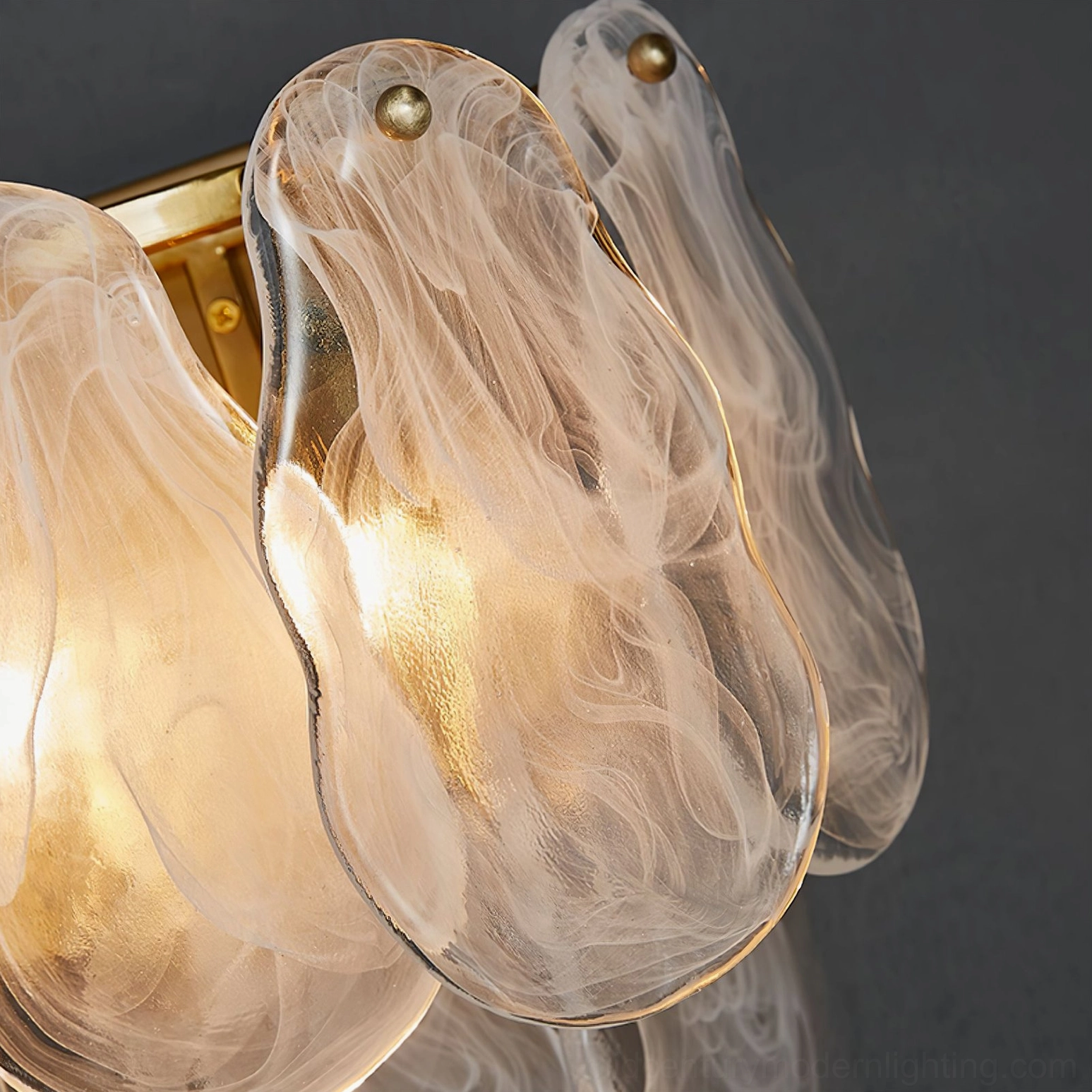 Mid-century modern cloud glass wall sconce with warm lighting, showcasing frosted glass craftsmanship and brass frame