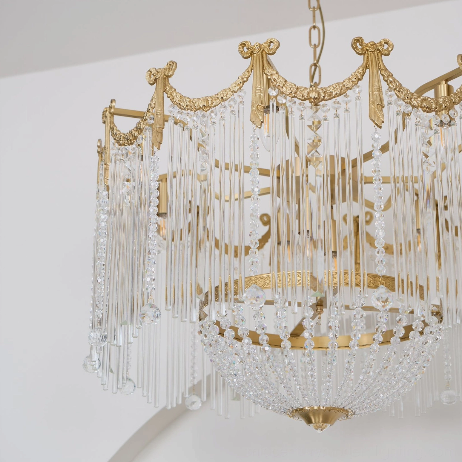 Mid-century modern style crystal chandelier with crown frame and teardrop glass pendants in home setting