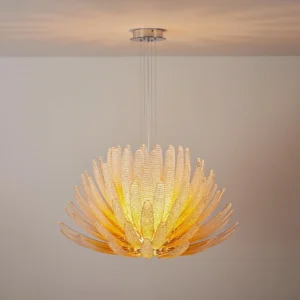 Hand-blown glass petal chandelier with warm amber tones illuminated modern interior setting