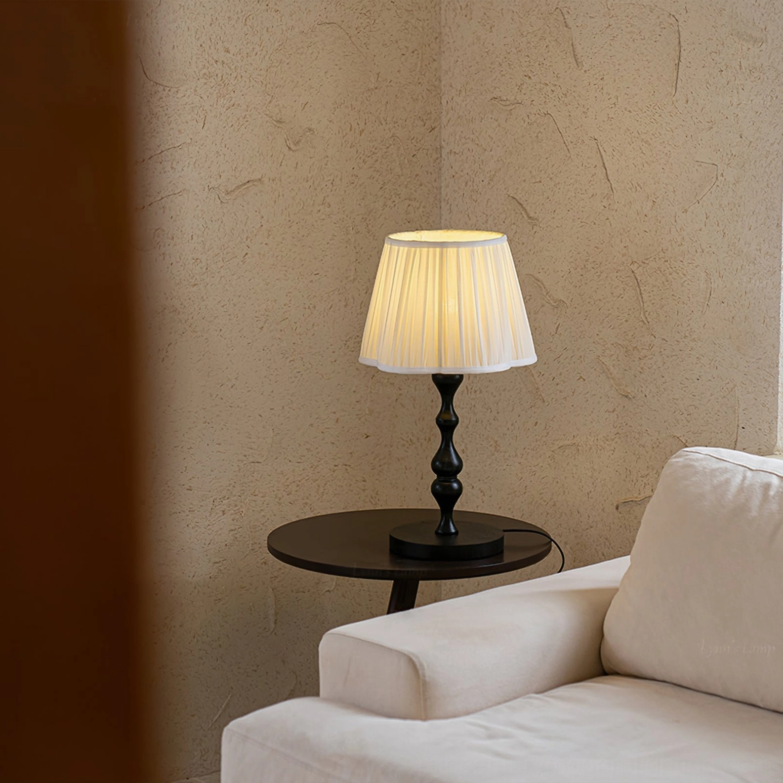 Ambrosia table lamp glowing with warm ambient light, showcasing elegant dark wooden base and illuminated fabric shade