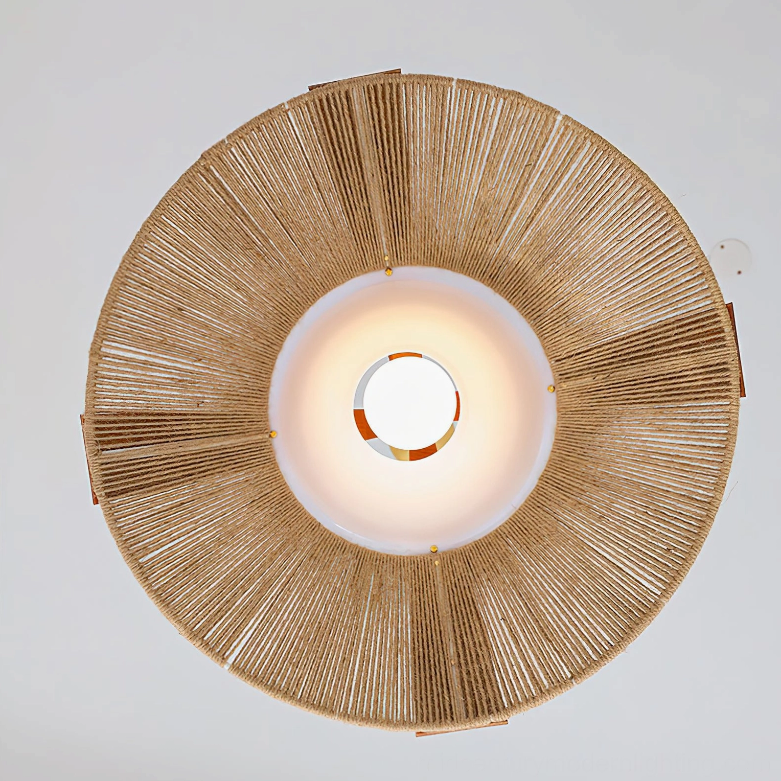 Artisanal pendant light fixture displaying natural material texture of raffia weave, wood structure, and mid-century modern minimalist design