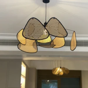 Screen cannage pendant light illuminated in modern residential living room, asymmetrical perforated rattan shades with warm ambient glow