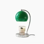 Scandinavian sphere table lamp with chrome metal base and glass globe shade on white studio background