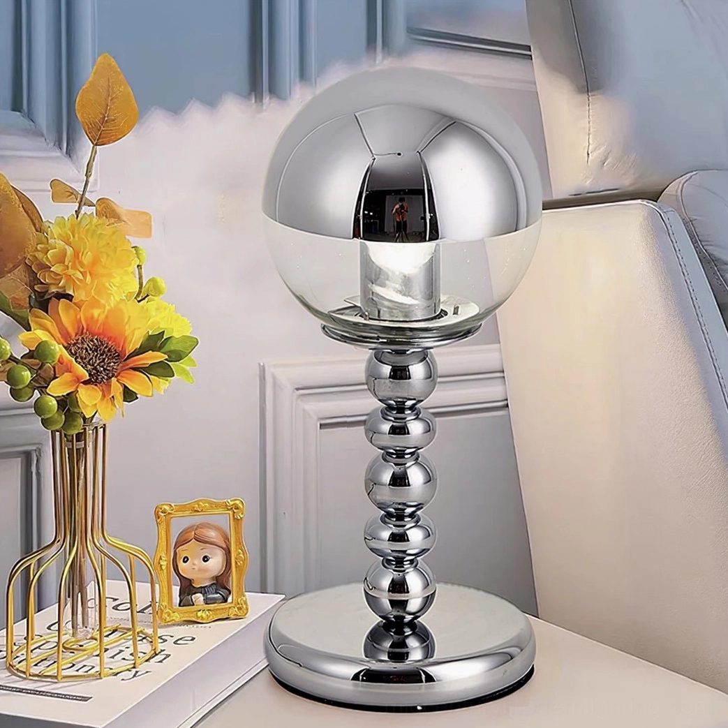 Chrome Mirrorball sphere lamp on modern living room side table with sunflower vase and photo frame