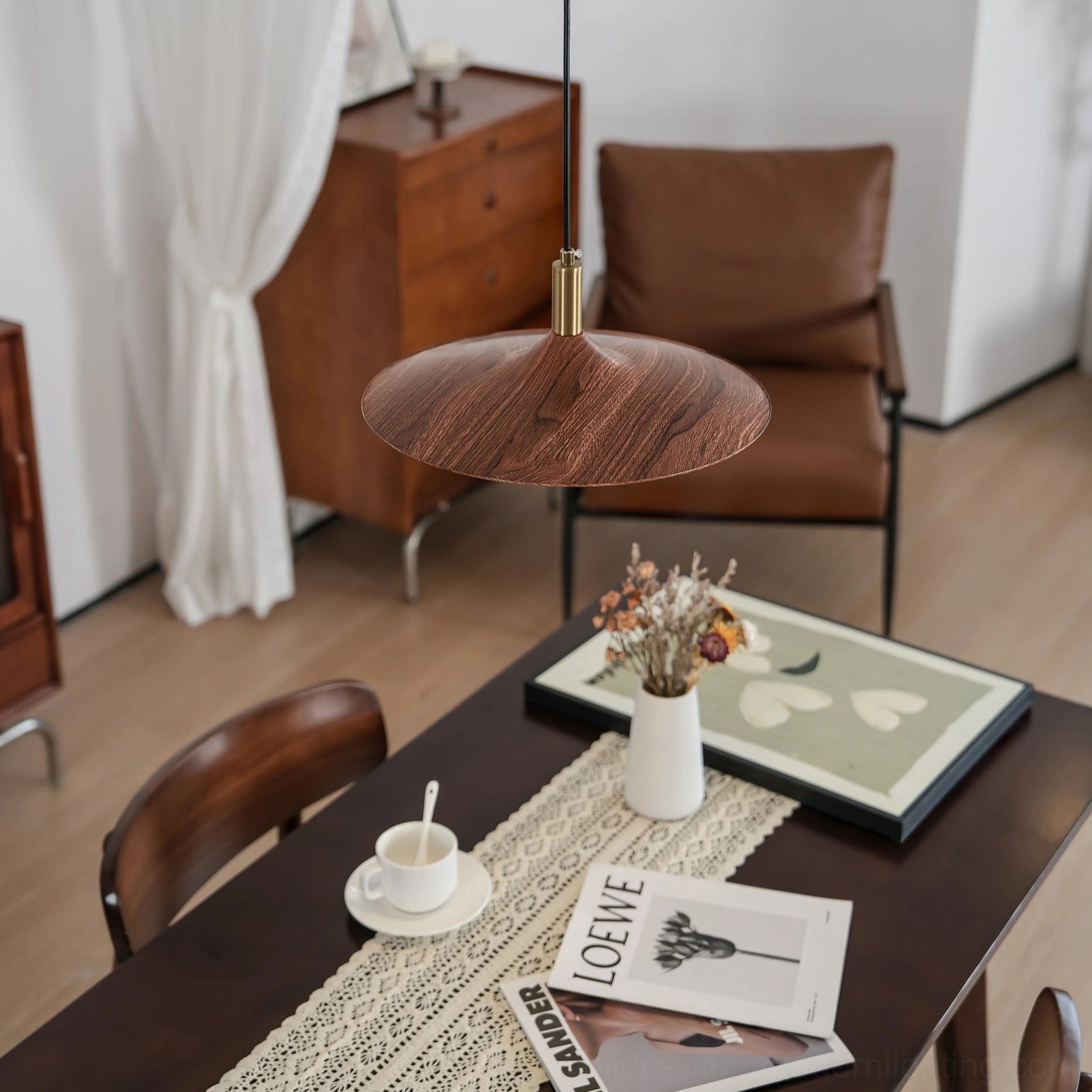 Walnut disc pendant light hanging above mid-century modern dining table warm ambient glow