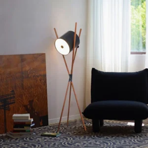 Mid-century modern floor lamp with natural wood tripod base and black shade in Scandinavian living room setting
