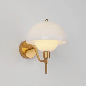 Close-up top-front detail of mid-century modern orb wall lamp showing brass hardware and matte glass shade with warm internal lighting