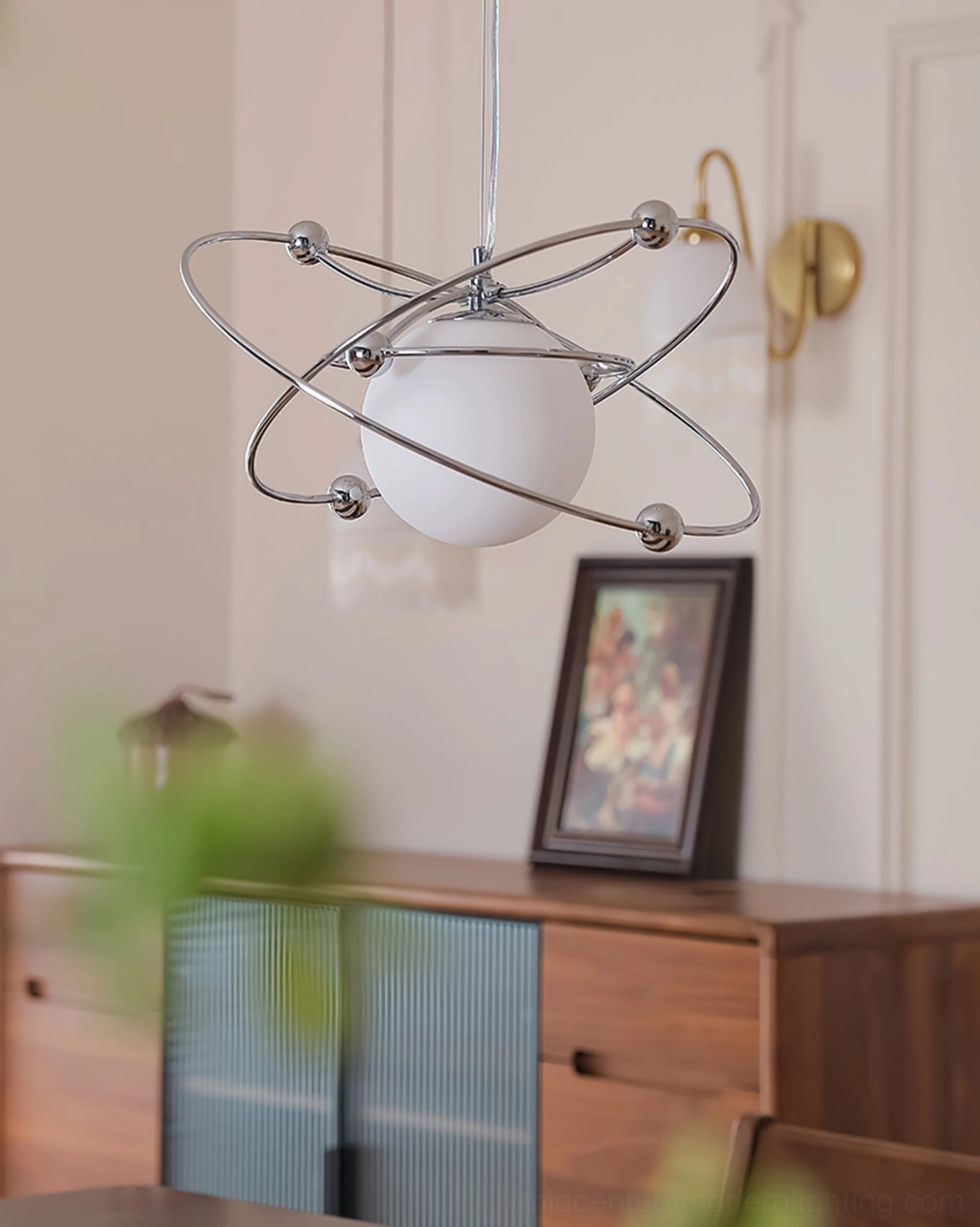 Mid-century modern orbital ceiling pendant in minimalist room with wooden sideboard
