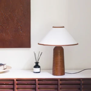 Modern table lamp styled on dark wood console with reed diffuser, three-quarter interior view