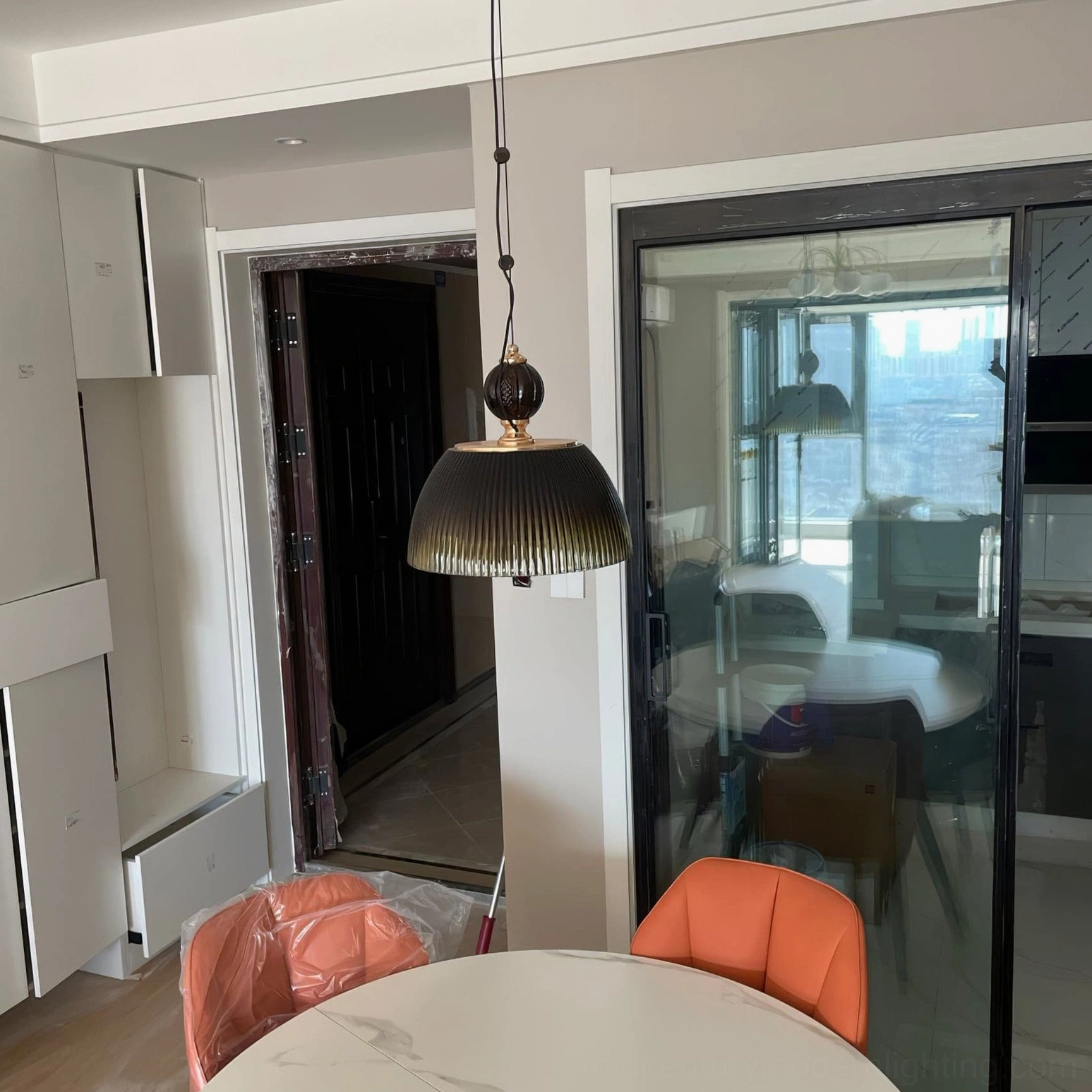 Hanging mid-century modern pendant lamp with green glass shade demonstrating warm ambient glow effect