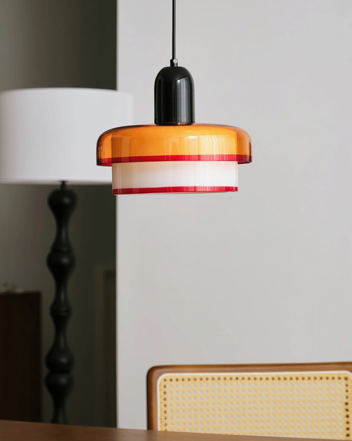 Angled view of retro mid-century pendant lamp in dining space with rattan furniture