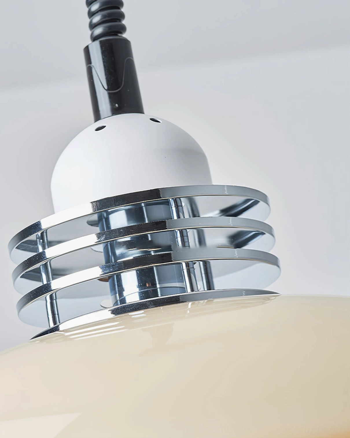 Overhead detail view of mid-century modern pendant lamp showing layered chrome metal mounting hardware on white background