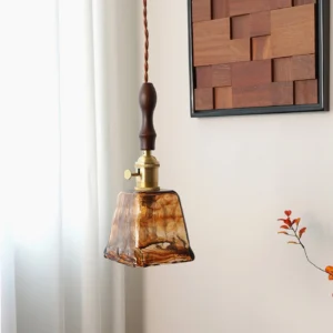 Mid-century modern pendant lamp with marbled amber glass shade illuminated in contemporary interior, showing exposed Edison bulb detail