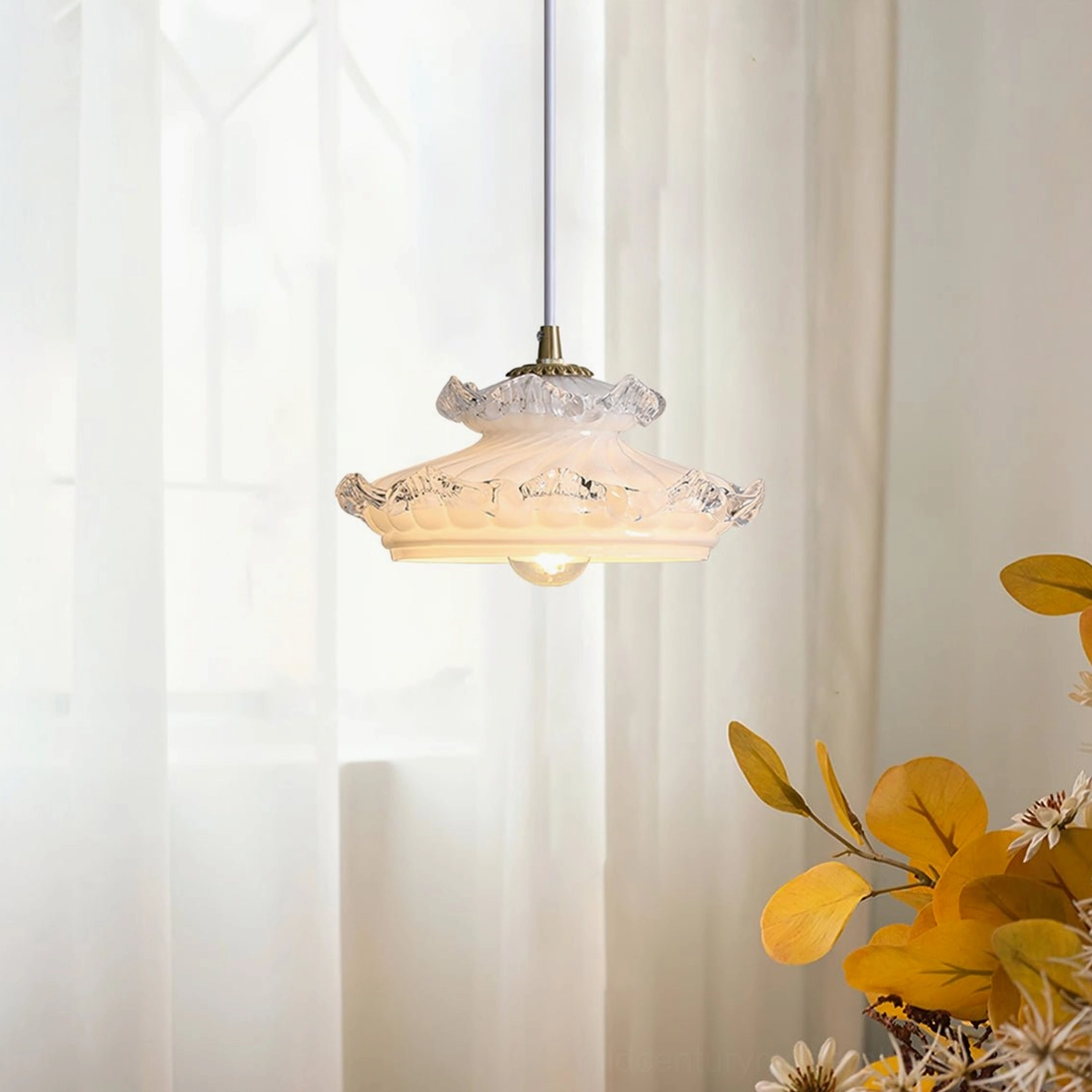 Hanging ceiling pendant light in sunlit room with sheer curtains - warm brass fixtures and ruffled glass edge