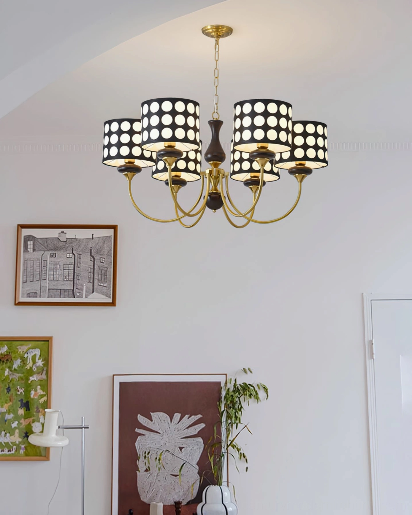 Mid-century modern polka dot chandelier with gold metal arms and black hollow dot shades, wall art background