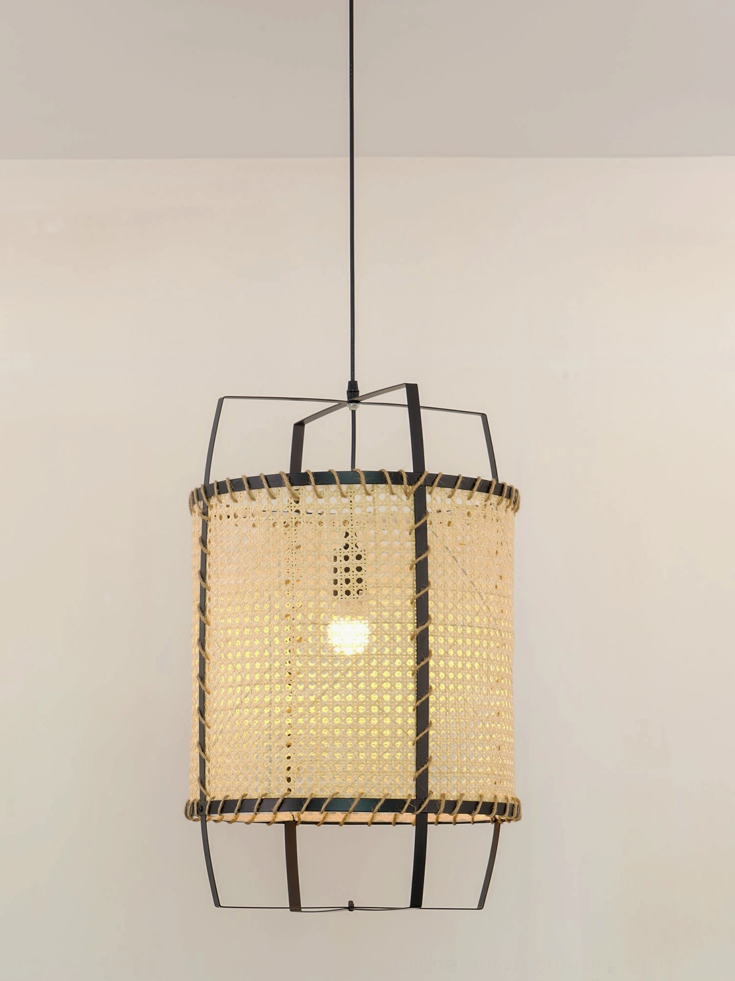 Close-up frontal view of mid-century modern rattan cane pendant light, emphasizing dark metal frame and tightly woven bamboo-rattan hybrid mesh
