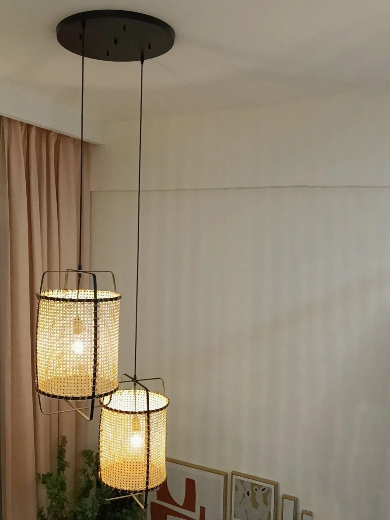Mid-century modern rattan cane suspension lamp with metal frame, natural woven mesh, displayed in scandinavian-inspired interior setting