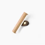Mid-century modern rotatable tube wall lamp in natural wood finish, studio overhead view with minimalist white background