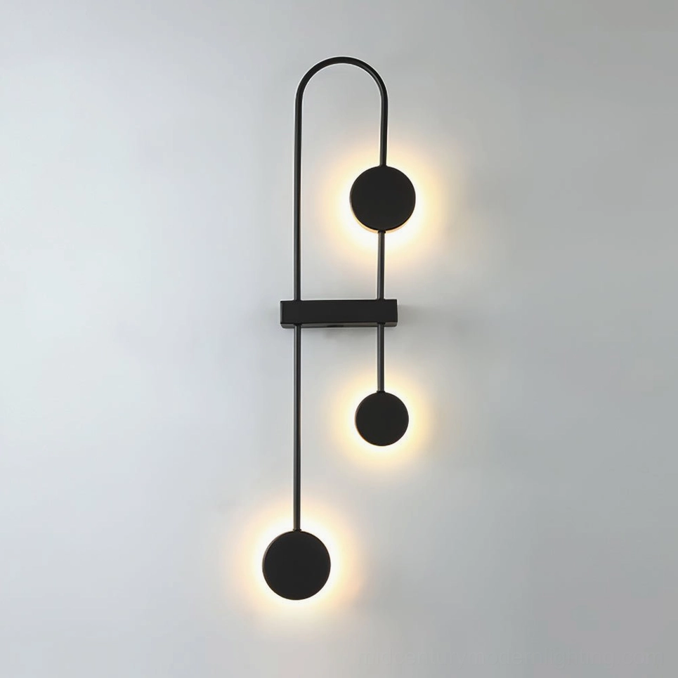 Mid-century modern wall sconce with matte black finish and sculptural pendant spheres