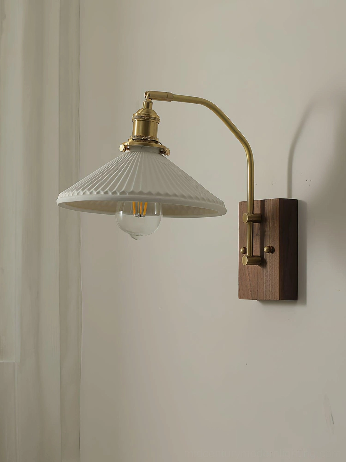 Mid-century modern wall sconce with white flared ribbed shade and exposed warm Edison bulb filament