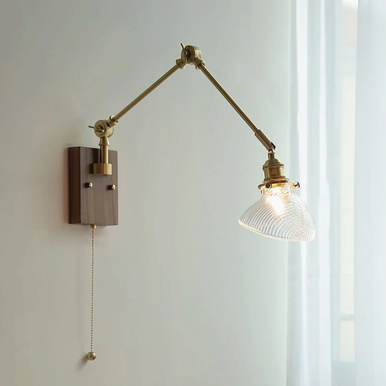 Side-view of mid-century modern swing arm lamp with clear glass shade and dark walnut wood base casting geometric light patterns