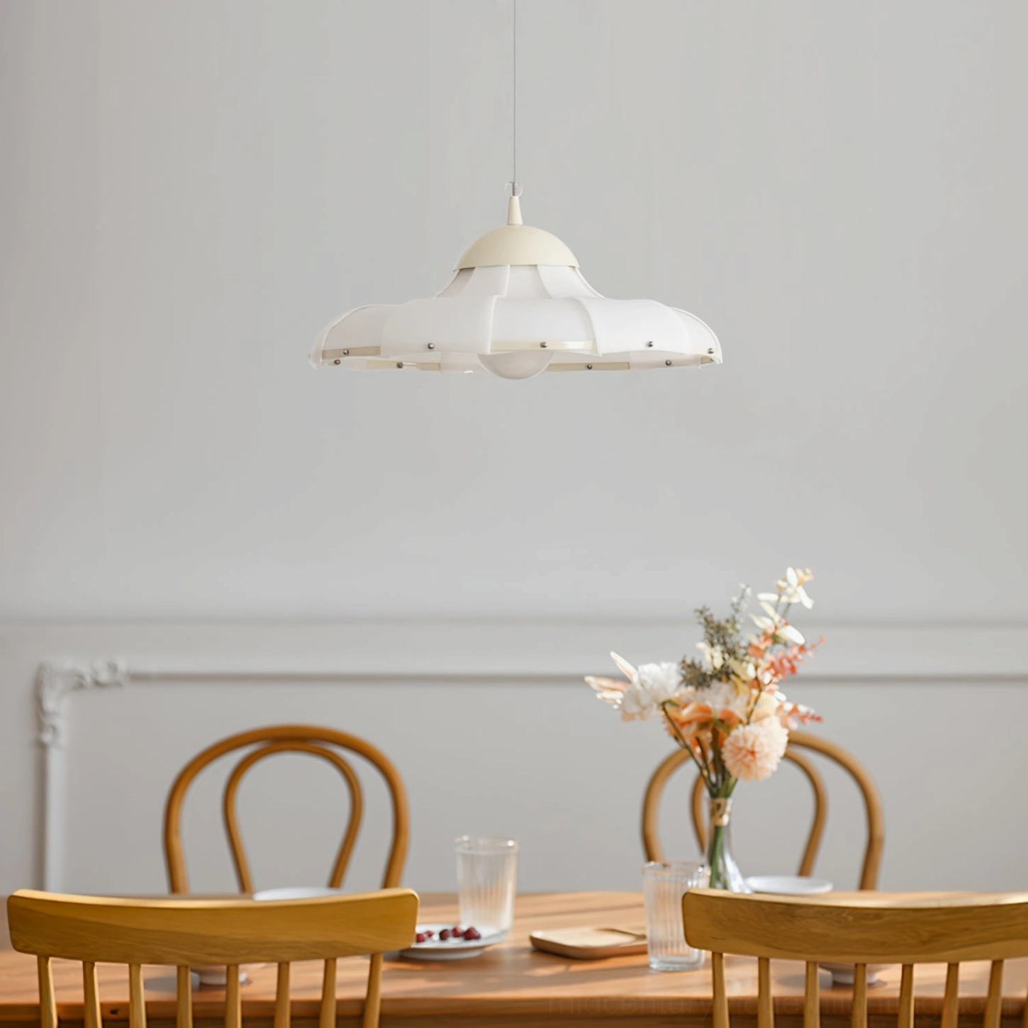 Mid-century modern swirl pendant lamp suspended above warm-toned wooden dining table and chairs