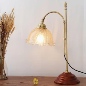 Vintage table lamp displayed on wooden table with dried flowers, side three-quarter view showing textured glass shade