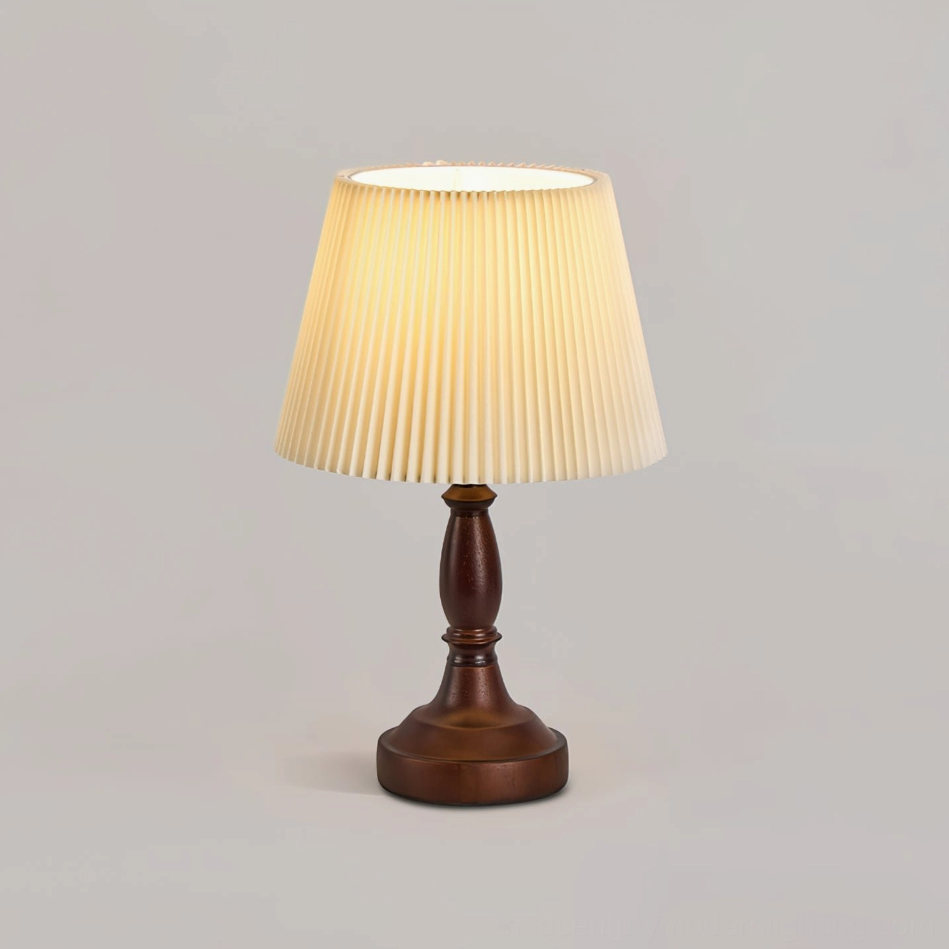 Walnut wood table lamp with glowing pleated shade showing warm ambient lighting quality