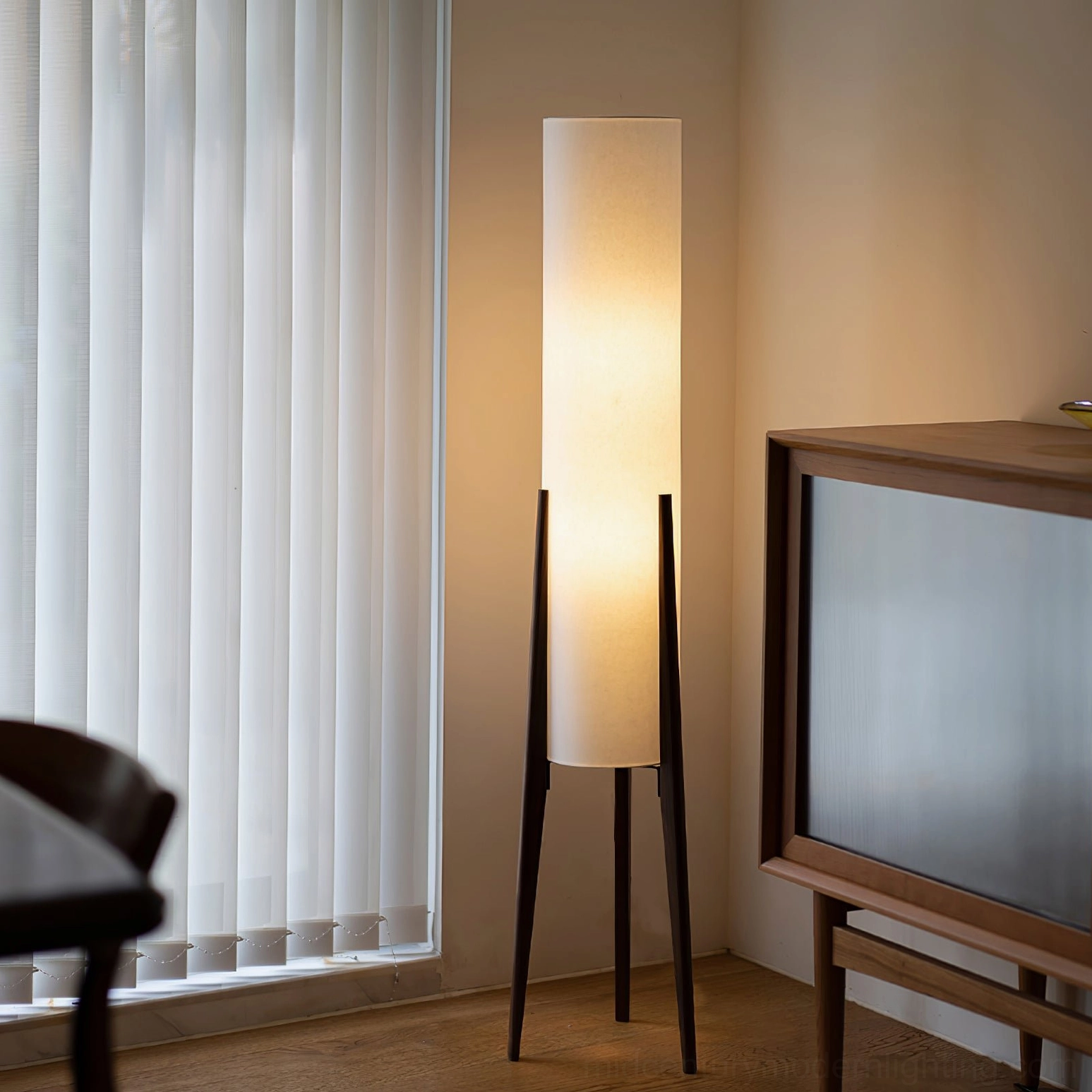 Walnut wood floor lamp with fabric shade in vintage living room interior, warm ambient lighting through window