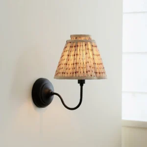 Mid-century modern wall sconce mounted on minimalist bedroom wall with window, three-quarter view