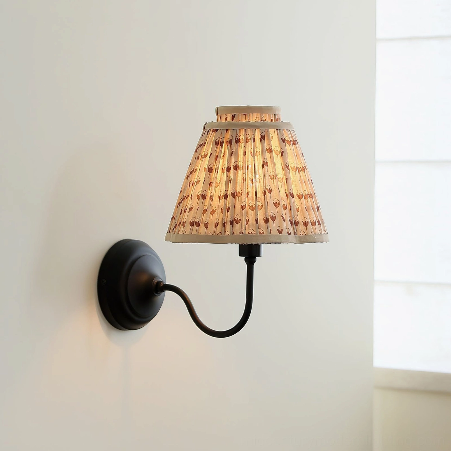 Mid-century modern wall sconce mounted on minimalist bedroom wall with window, three-quarter view
