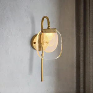 Brass wall sconce mounted on concrete wall with warm ambient lighting and minimalist design aesthetic