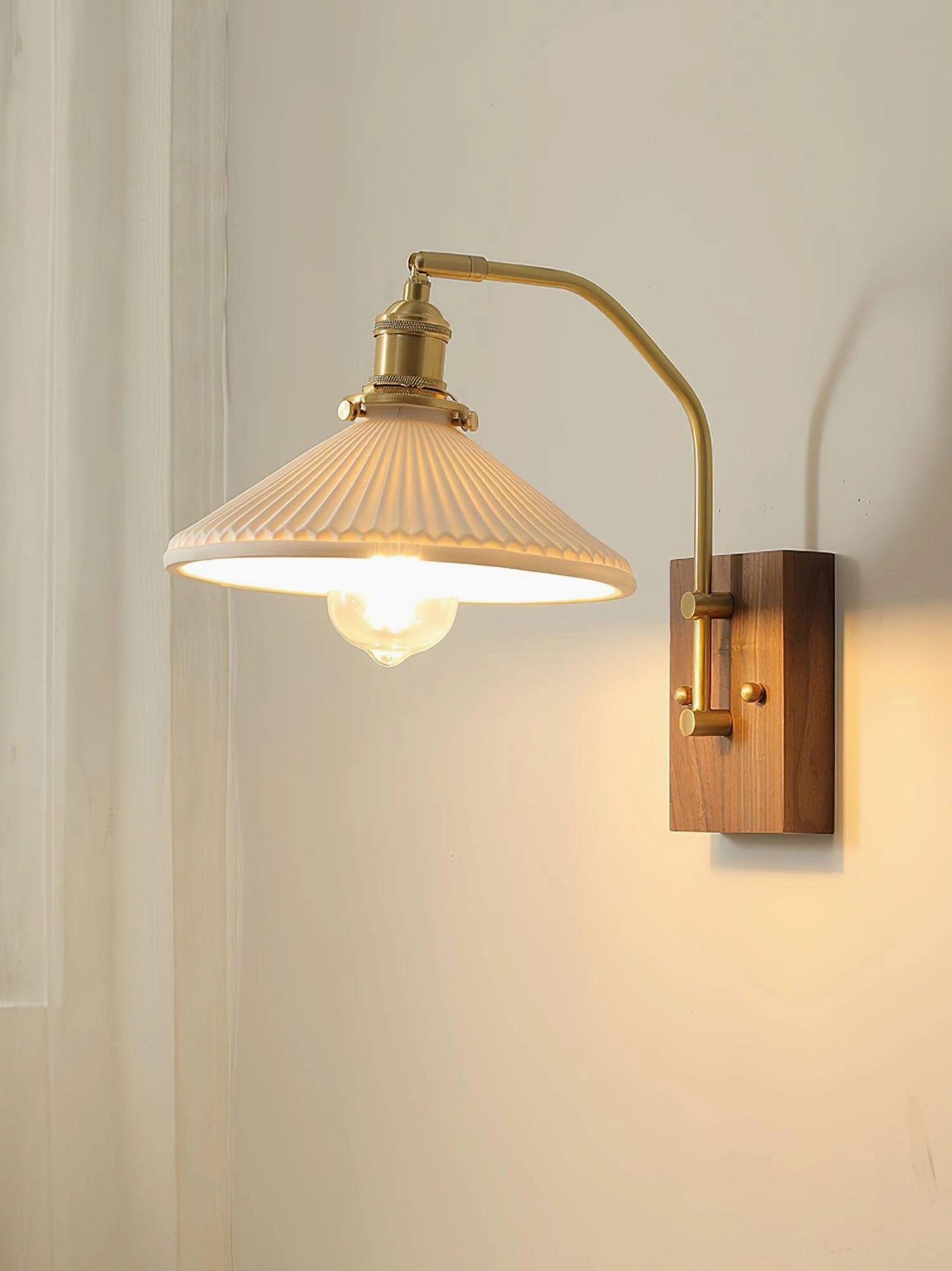 Wall sconce with exposed Edison bulb and flared ribbed ceramic shade showing mid-century design details