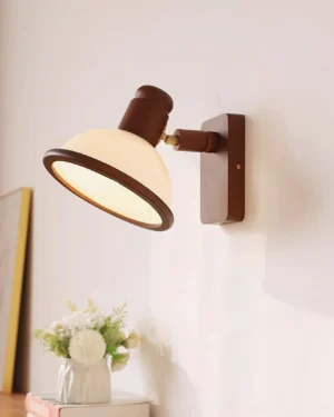 Mid-century modern wall lamp with warm adjustable arm design, styled in cozy home interior with books and flowers