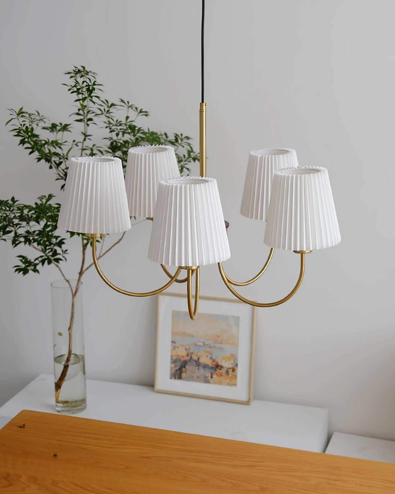 Wooden chandelier with radiating arms displayed in bright entryway with decorative plants