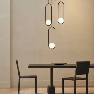 Mila multi-head pendant lights creating warm ambient lighting over minimalist dining area with neutral interior