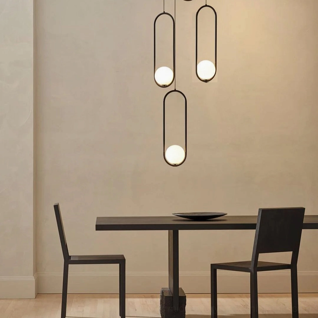 Mila multi-head pendant lights creating warm ambient lighting over minimalist dining area with neutral interior