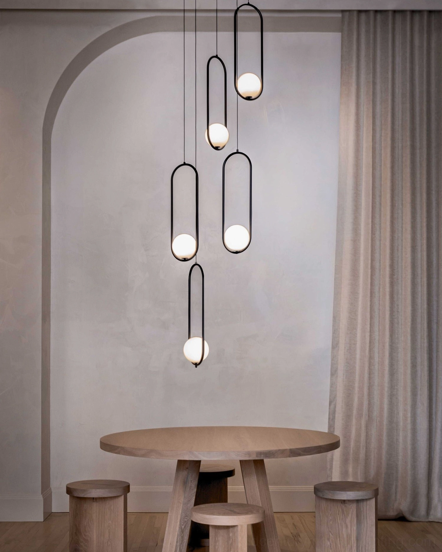 Mila vertical pendant lamp set with matte black hardware illuminating cozy dining nook with arched architectural details