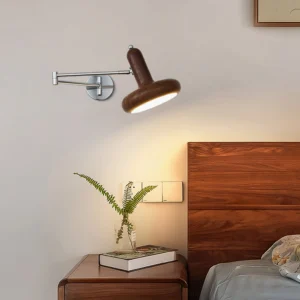 Milena wall-mounted reading light in warm wood tone positioned at bedside, Nordic minimalist bedroom setting with soft natural light