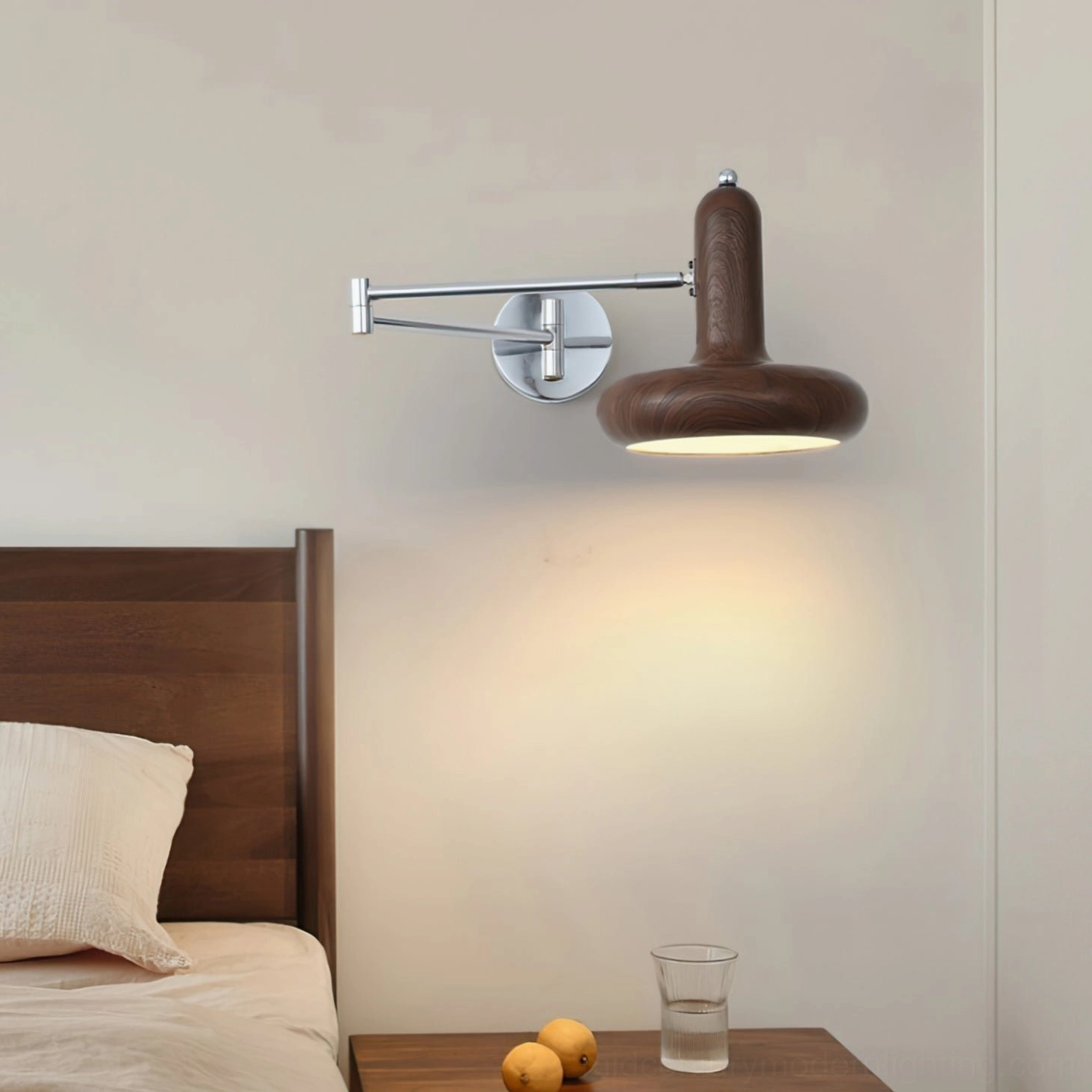 Milena swing arm wall lamp with dark walnut wood grain finish mounted above wooden headboard, side-view installation