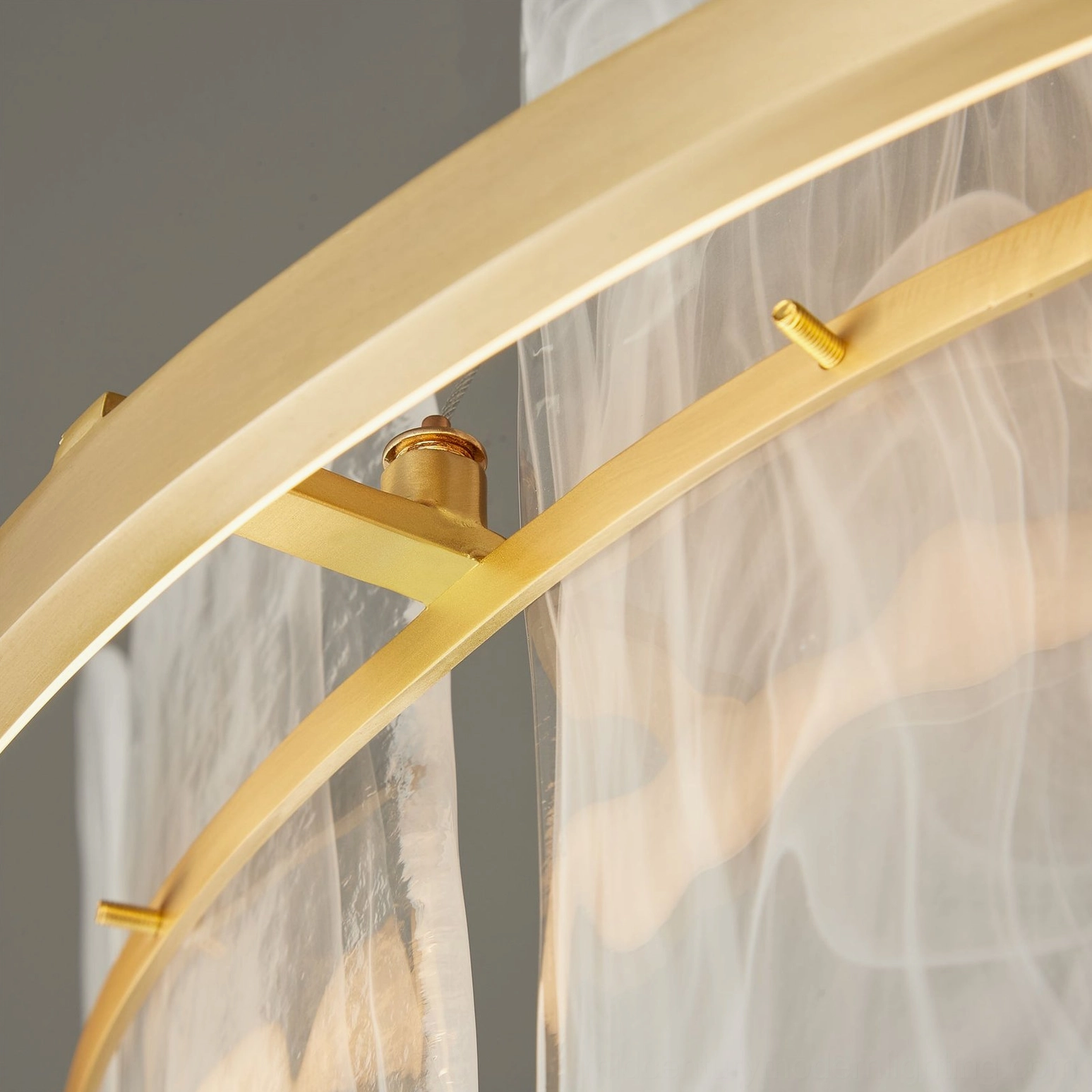 Extreme close-up of Mille Round Glass Chandelier brass screws and wavy glass texture