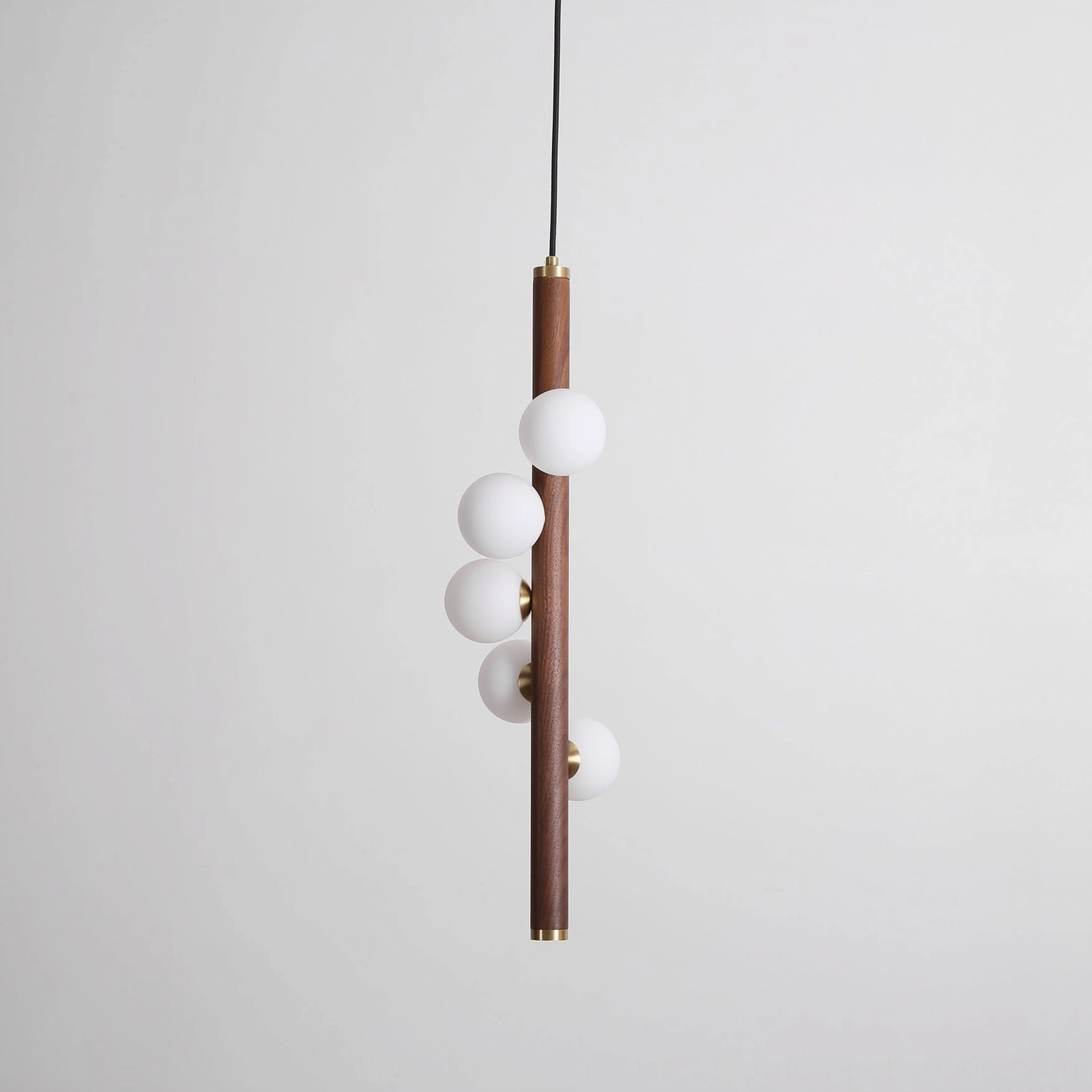Miller wooden pendant light with brass accents and frosted glass globes, close-up detail of natural wood grain